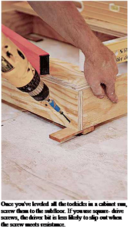 Подпись: Once you've leveled all the toekicks in a cabinet run, screw them to the subfloor. If you use square- drive screws, the driver bit is less likely to slip out when the screw meets resistance. 