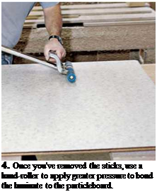 Подпись: 4. Once you've removed the sticks, use a hand-roller to apply greater pressure to bond the laminate to the particleboard. 