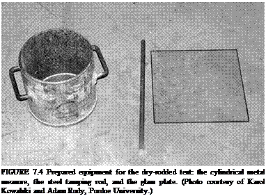 Подпись: FIGURE 7.4 Prepared equipment for the dry-rodded test: the cylindrical metal measure, the steel tamping rod, and the glass plate. (Photo courtesy of Karol Kowalski and Adam Rudy, Purdue University.) 