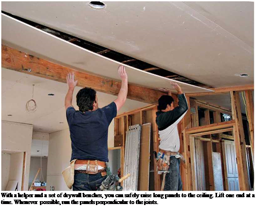 Подпись: With a helper and a set of drywall benches, you can safely raise long panels to the ceiling. Lift one end at a time. Whenever possible, run the panels perpendicular to the joists. 