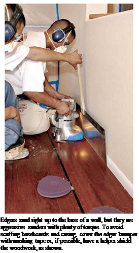 Подпись: Edgers sand right up to the base of a wall, but they are aggressive sanders with plenty of torque. To avoid scuffing baseboards and casing, cover the edger bumper with masking tape or, if possible, have a helper shield the woodwork, as shown. 