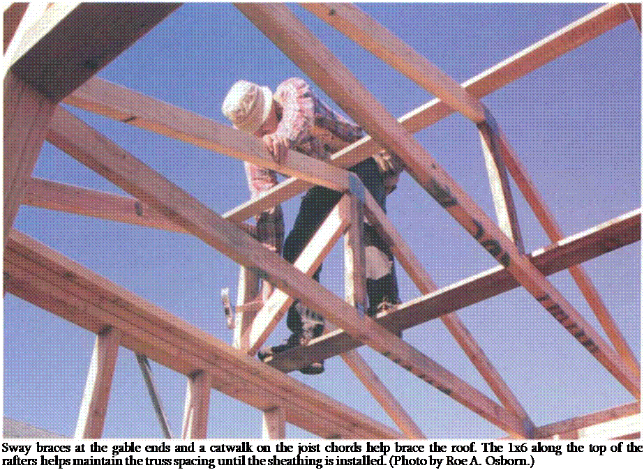 Подпись: Sway braces at the gable ends and a catwalk on the joist chords help brace the roof. The 1x6 along the top of the rafters helps maintain the truss spacing until the sheathing is installed. (Photo by Roe A. Osborn.) 