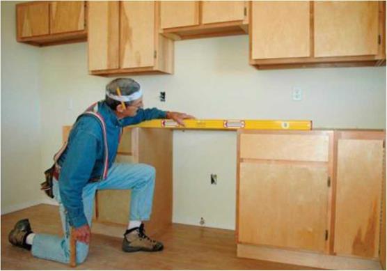 Install the base cabinets in kitchens and baths